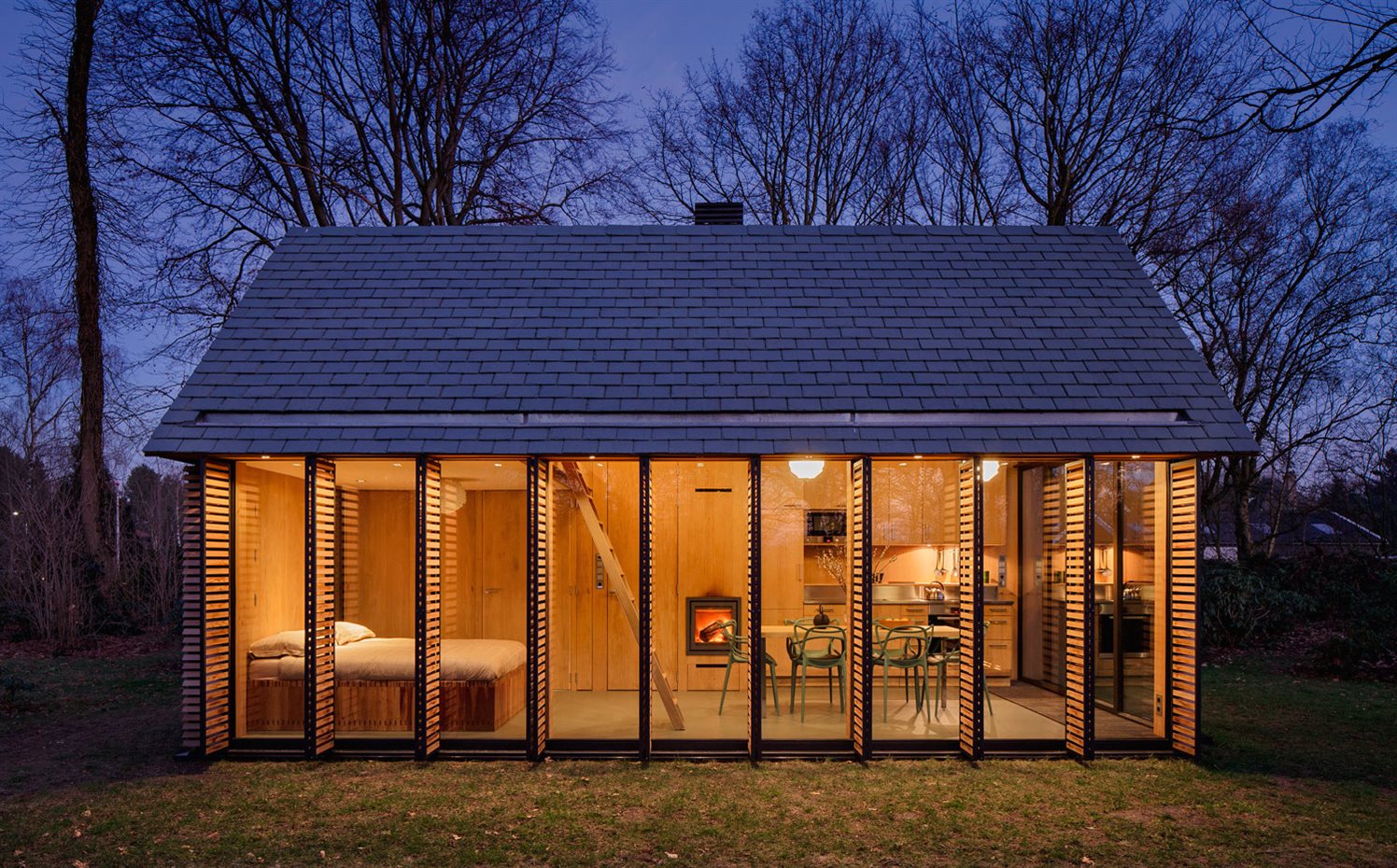 SP2015-Zecc-Tuinhuis-20-HiRes. Cuando cae la luz, con la iluminación interior, es perfectamente observable desde fuera la disposición longitudinal del pequeño espacio en dos zonas principales, la de día y la de noche