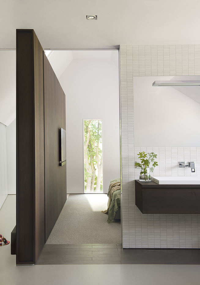 00409922 ok. Un panel de roble ahumado delimita el espacio del dormitorio y el baño principal. Lavamanos, de Corian. La grifería es del fabricante Grohe