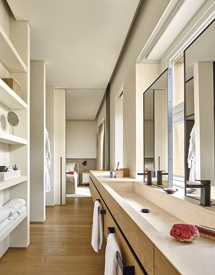 00413258 ok. El lavamanos, diseñado por Fabio Fantolino, es de mármol satinado Galala. Los espejos, enmarcados con hierro, son también un diseño del arquitecto