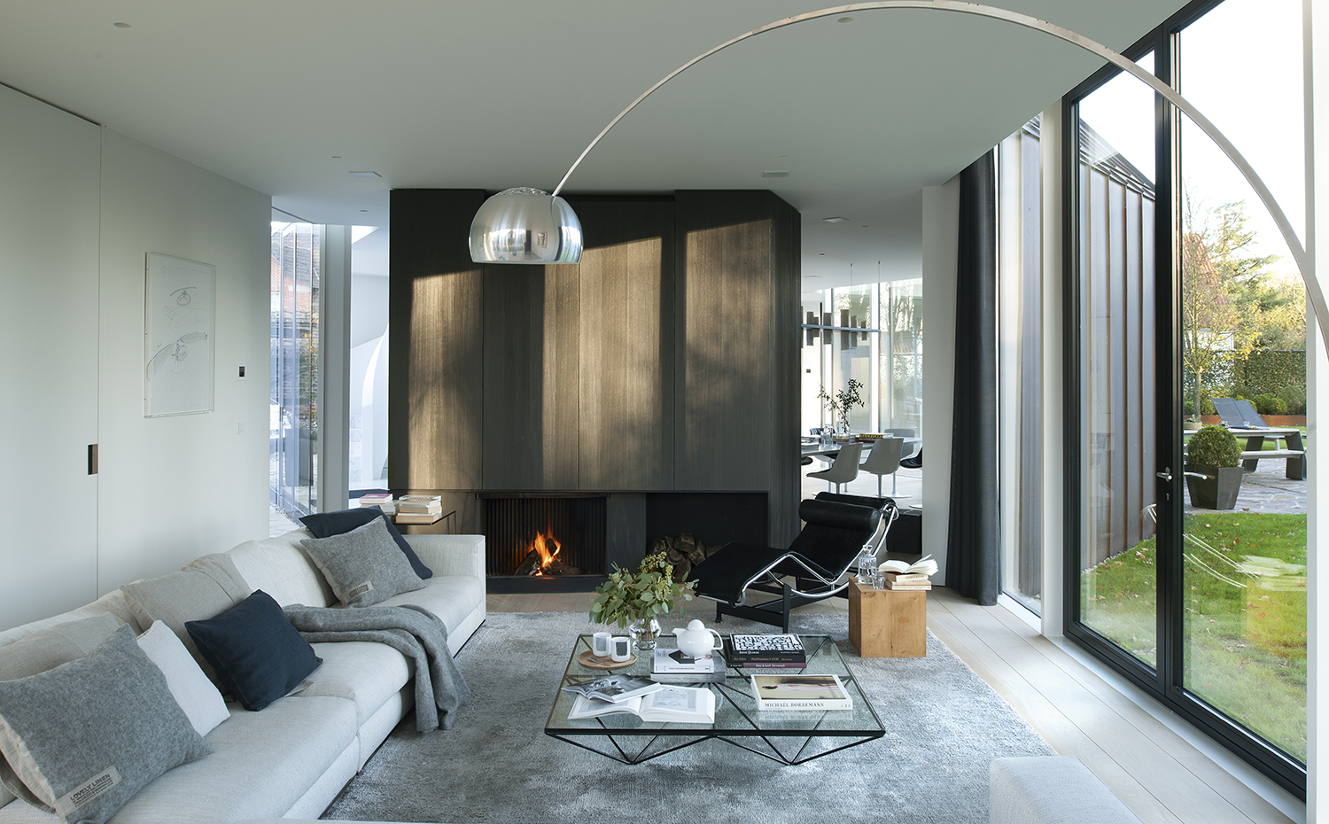 00426859 ok. La chimenea es un diseño de los arquitectos. Mesa de centro Alanda, Paolo Piva para B&B Italia. Sofá de Minotti con cojines de la firma Kardelen. Lámpara Arco, de los Castiglioni para Flos