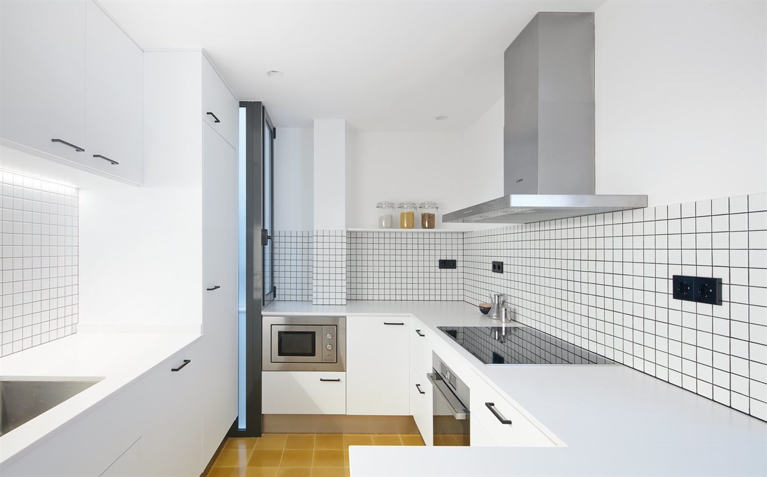 PISO-2DEMAIG-07. Las pequeñas teselas que forman el mosaico de la cocina, en blanco, aportan luz al espacio. Campana extractora de Bosch
