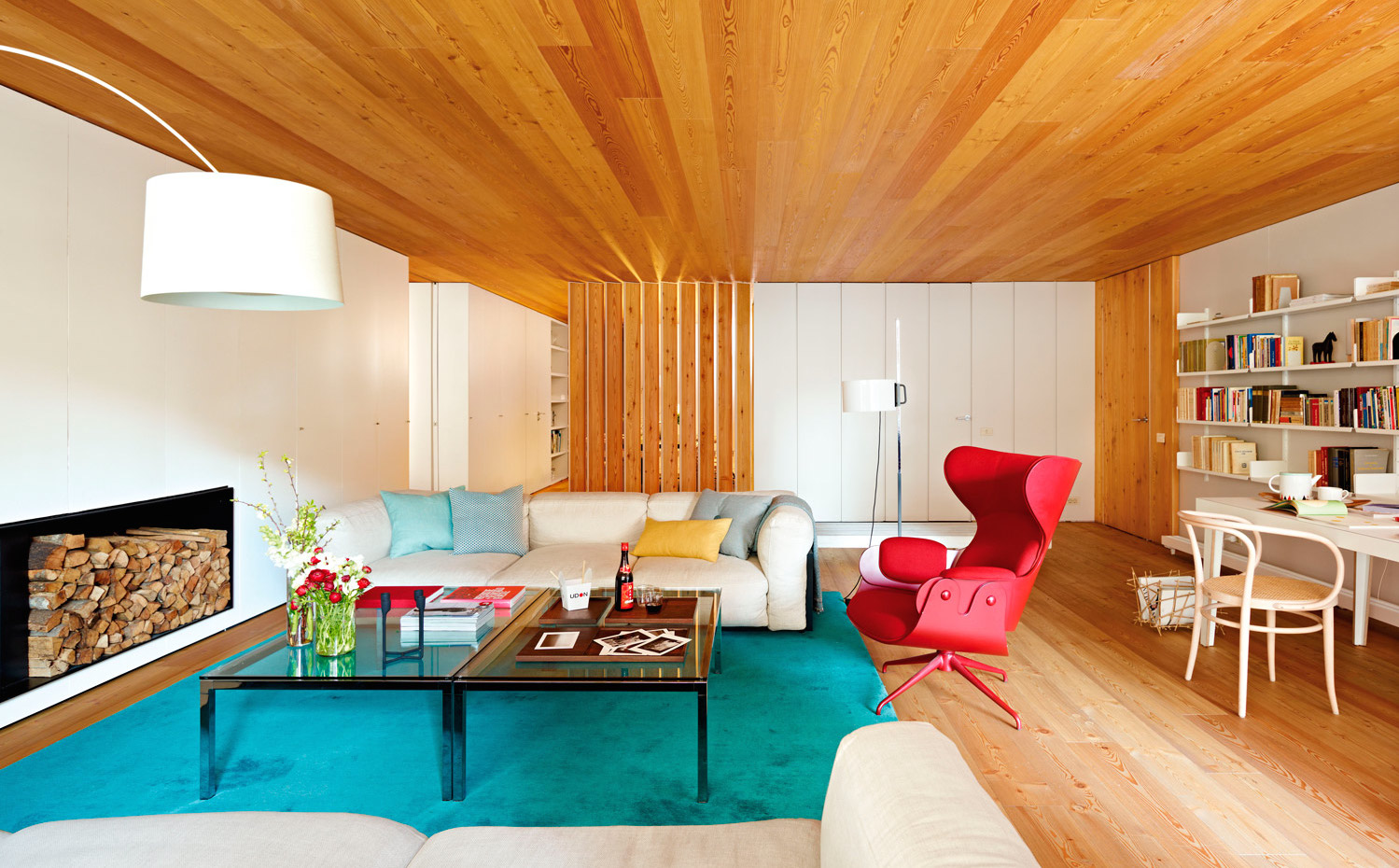 00338115. La madera es de alerce, parecida a la del pino silvestre. La butaca roja es la Lounger, de Jaime Hayón para Bd Barcelona Design, adquirida en Domésticoshop. Lámpara de pie TCM, de Miguel Milá para Santa & Cole, en Castamitjana