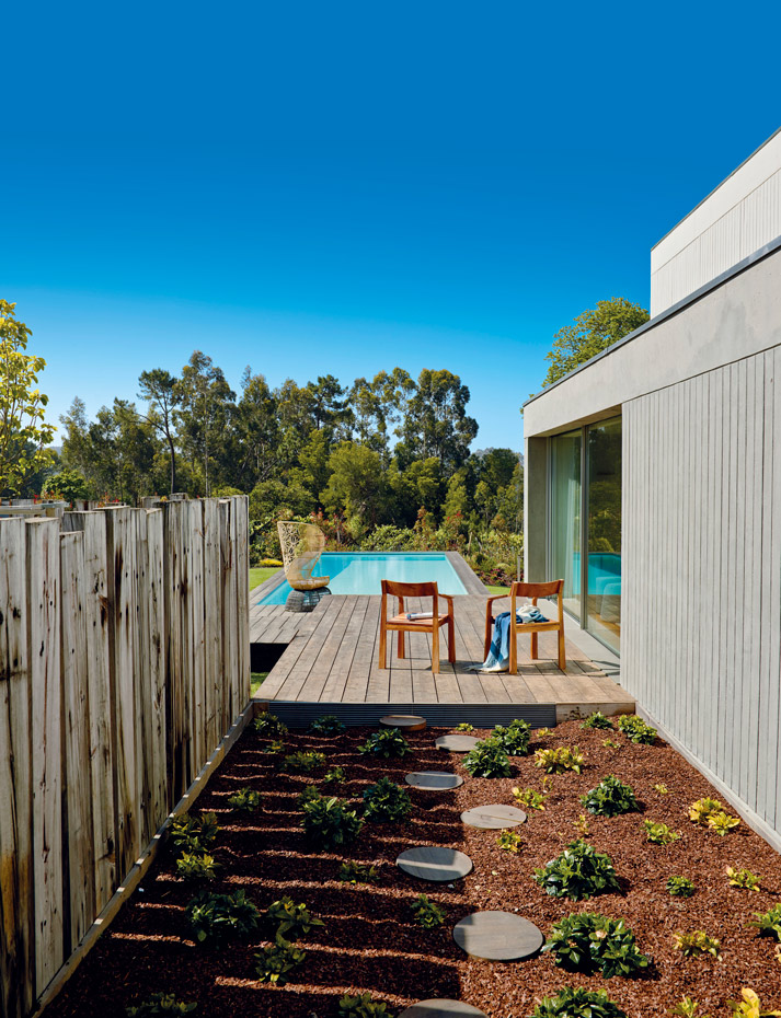 00367525. Un pequeño huerto proporciona hierbas aromáticas. Sobre la tarima de madera que rodea la piscina, sillas de exterior diseñadas por el arquitecto Nelson Resende