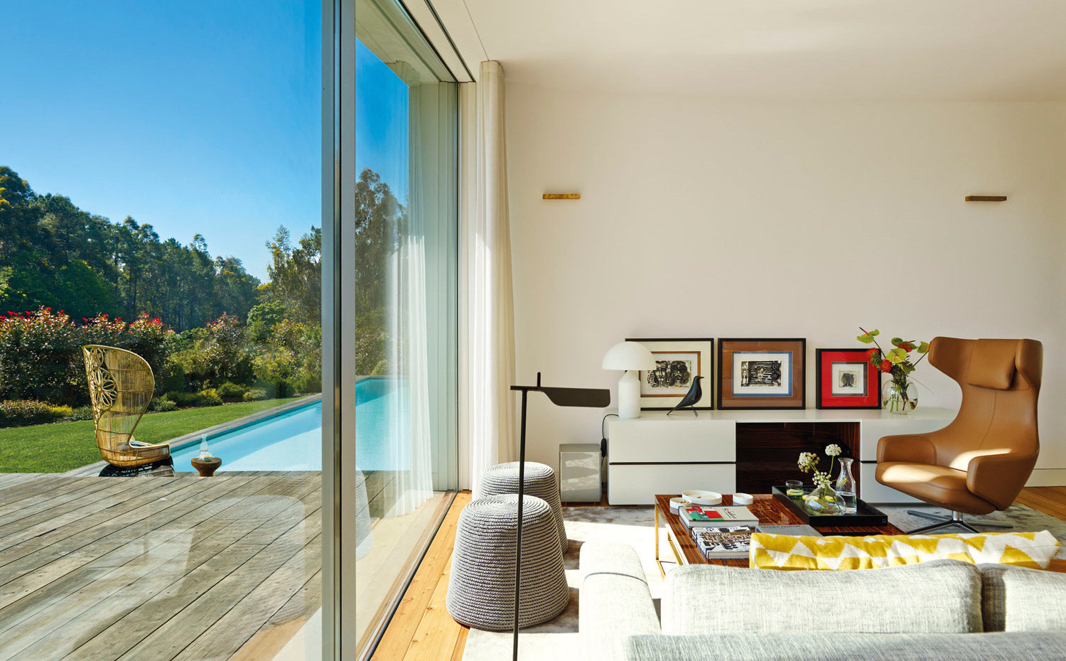00367527. En primer plano, lámpara Tab, diseño de Berber & Osgerby para Flos. Los cuadros son del artista Carlos Santos. El mueble bajo, a medida. Sobre este, la lámpara Atollo, de Vicco Magistretti para Oluce