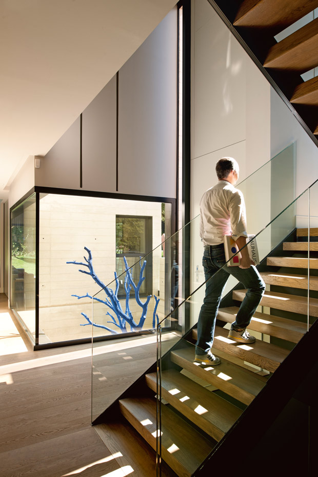 00391859. El patio funciona como una linterna que proyecta luz natural por los interiores. La escalera de acceso al nivel superior se ha resuelto con peldaños de roble sin contrahuella y pasamanos de cristal