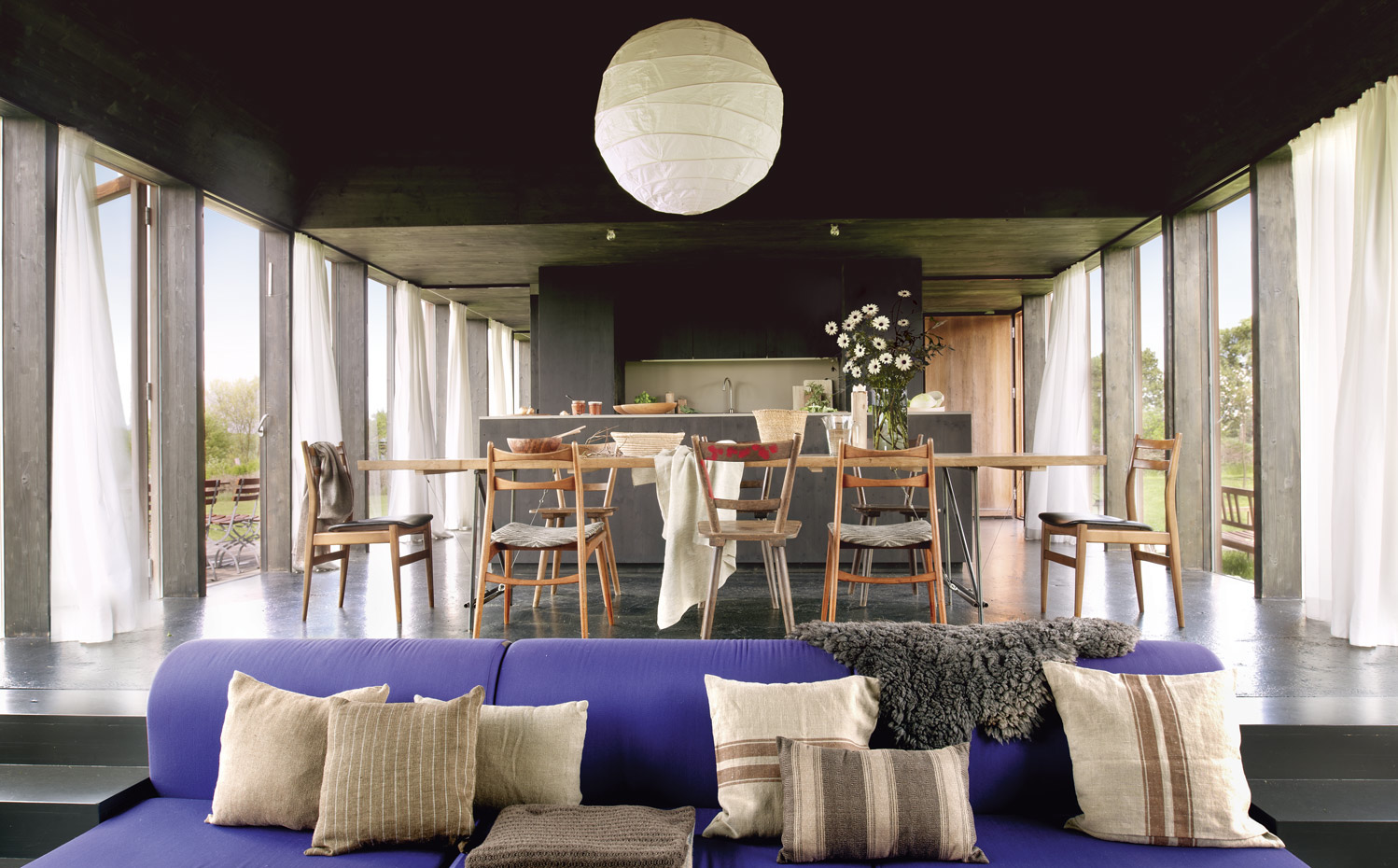 041 DSC7156. En el estar, un sofá, de Ikea, con cojines en tonos beige y marrón, de Teixidors, adquiridos en Matèria. La mesa del comedor es un diseño del arquitecto realizado a medida. La lámpara se ha comprado en Asia Store, mientras que las sillas son antiguas