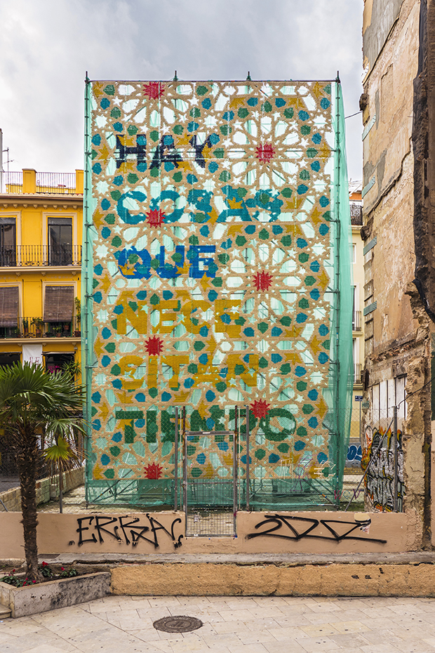 Obra mural "Hay cosas que necesitan tiempo" de Raquel Rodrigo, instalada en el centro histórico de Valencia durante el festival de arte Intramurs