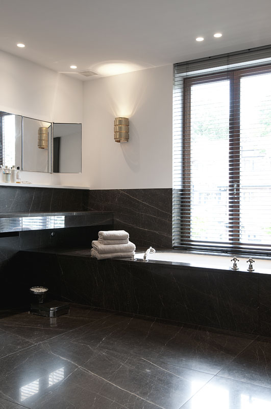 TK Residence A 11 bis. Los apliques del baño son vintage, algo que el propietario pidió expresamente. El mármol negro decora con elegancia suelo y picas de esta zona de aguas
