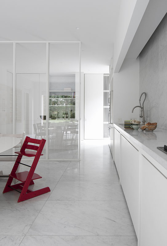 TK Residence A 3 bis. La pared de cristal y acero blanco que separa las dos zonas principales de la cocina y facilita la distribución es uno de los elementos decorativos estrella