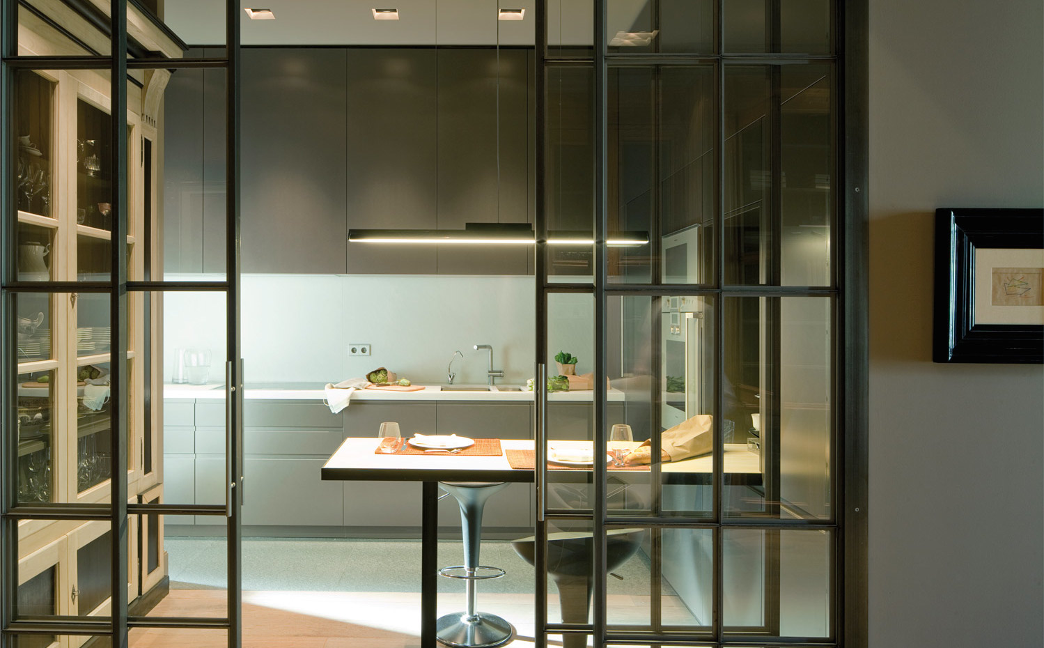 00368862 O. Dos puertas correderas con cuarterones de cristal franquean el acceso al office. Los taburetes son el modelo Bombo, diseño de Stefano Giovannoni para Magis