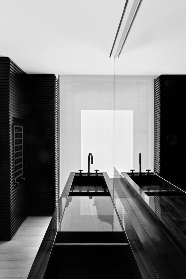 TAG72. El contraste de texturas y colores continúa en el baño, con el lavamanos y las paredes revestidas de color oscuro