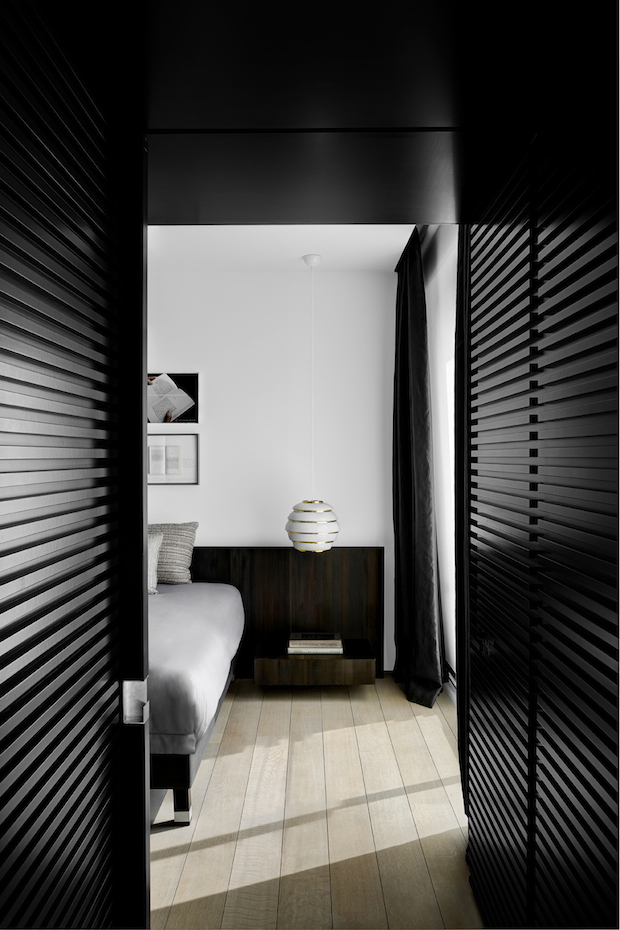 TAG73. La entrada al dormitorio, franqueada por paneles de aluminio negro, evoca el ingreso en un reducto recogido e íntimo, una especie de cueva contemporánea