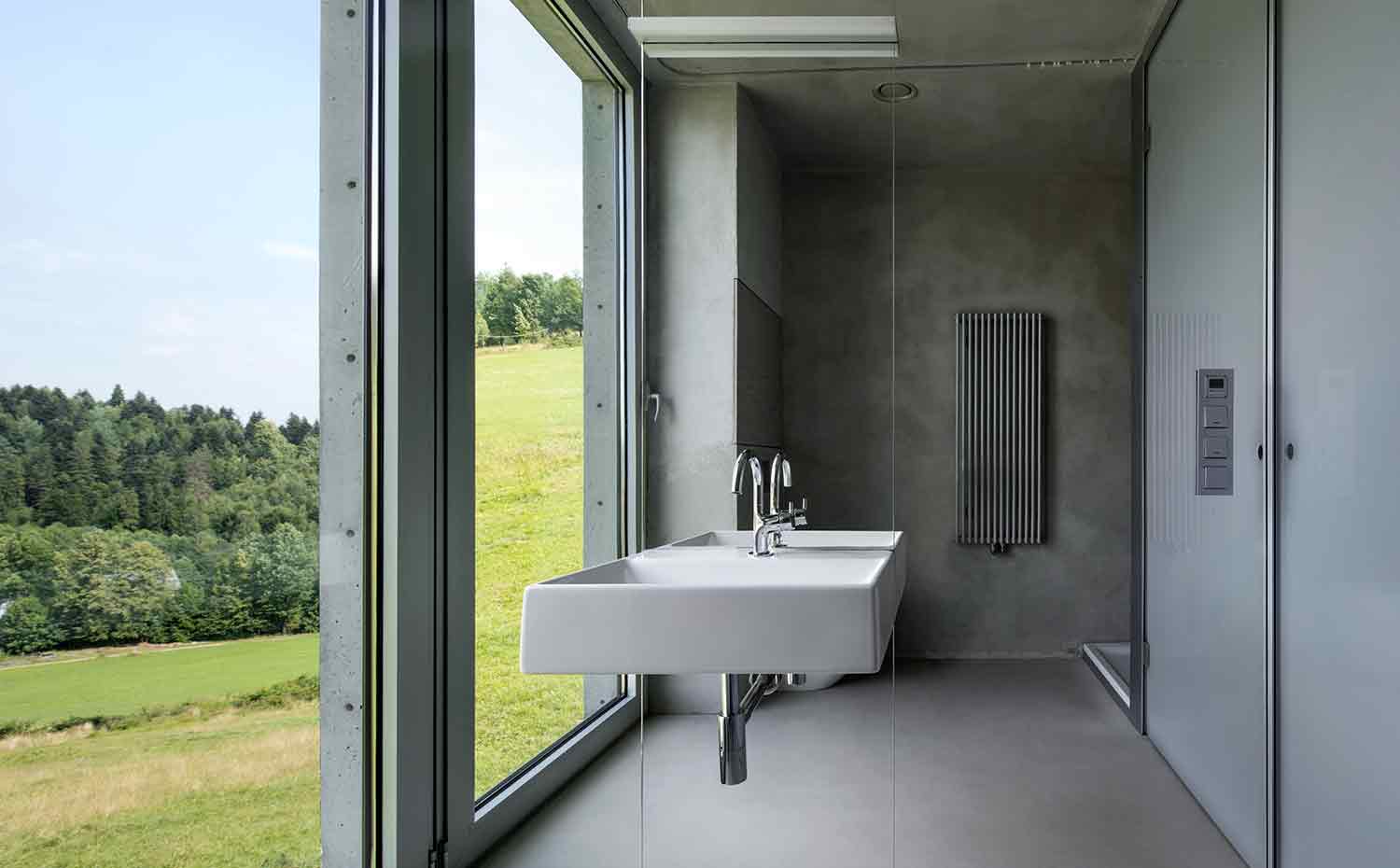 59 INTERIOR Konieczny's-Ark KWK-Promes-Robert-Konieczny photo-Olo-Studio. El lavamanos se sostiene en el baño en una pared revestida con un espejo