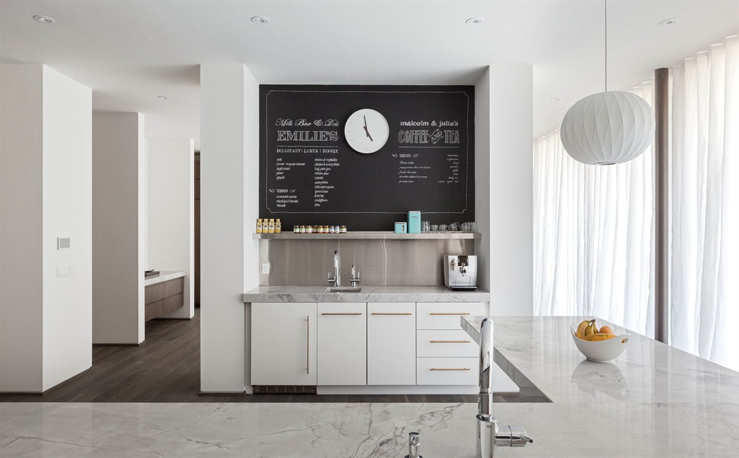 Interior-Shots-13. El blanco predominante de los interiores queda equilibrado por la tonalidad oscura de los suelos de madera y algunos detalles decorativos, como la pared de pizarra de la cocina
