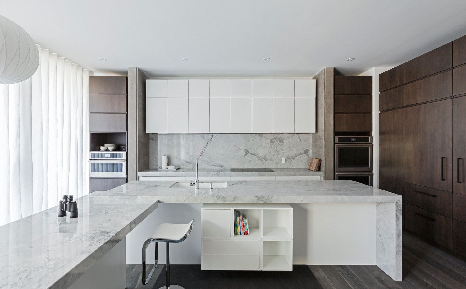 Interior-Shots-15. La cocina se organiza a partir de un bloque de pared y una isla prolongada perpendicularmente con una barra de desayunos