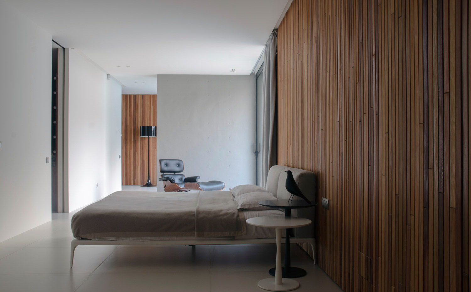 0021. La pared de madera hace de cabecero de la cama modelo Charles de Antonio Citteiro para B&B Italia. La silla es la Eames Lounge, de Charles & Ray Eames para Vitra