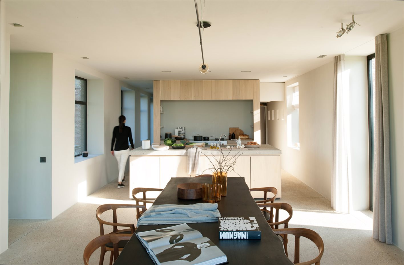 00430249 O. Cocina y comedor comparten un mismo ambiente. Sobre la encimera de la isla, recipientes blancos diseñados por Vincent van Duysen y un plaid de Ivano Redaelli