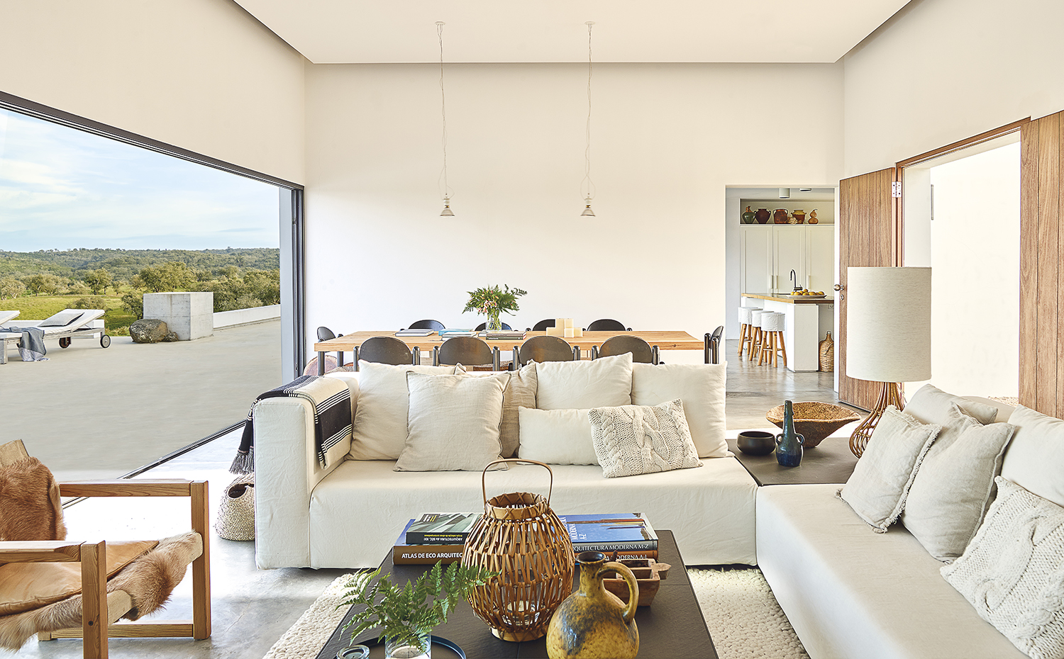 00433154. Salón y comedor comparten una misma estancia, amplia y comunicada con la terraza a través de un gran hueco apaisado. Todos los materiales empleados (hormigón, madera, hierro, piedra, tejidos naturales...) guardan coherencia con la idea de autenticidad que busca el proyecto