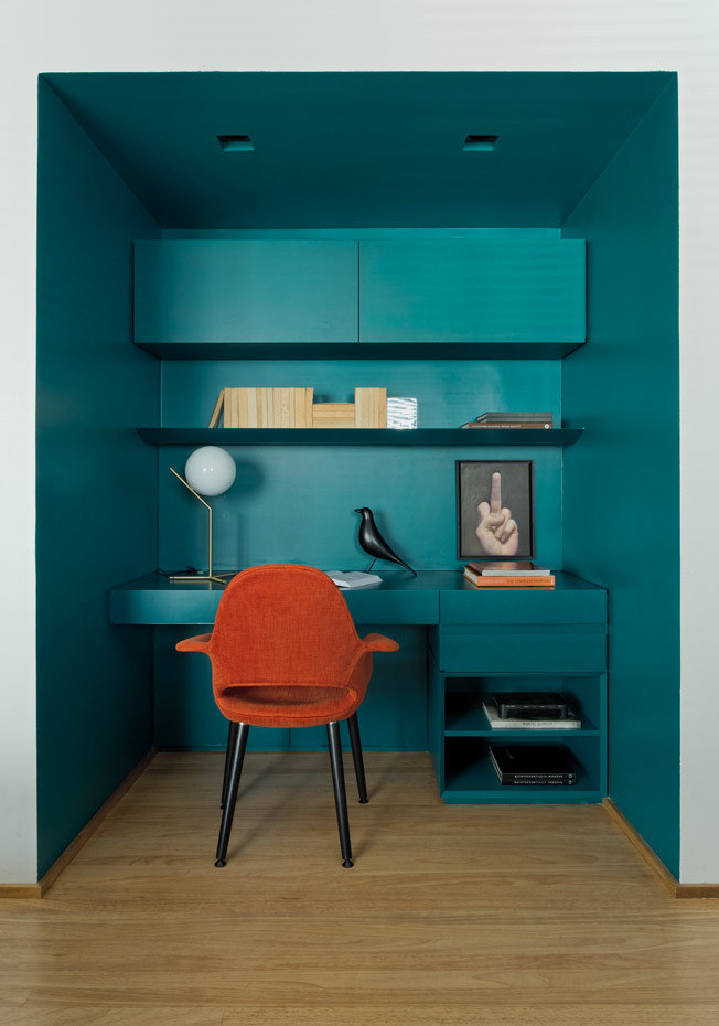  N0A7706 DxO. En la zona de estudio, el azul petróleo contrasta con una butaca de color coral. Lámpara de sobremesa IC Light, de Michael Anastassiades para Flos