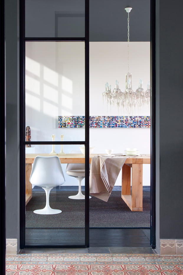 00373177. Las sillas Tulip, diseñadas por Eero Saarinen y editadas por Knoll, se combinan con la mesa Atelier, de Vincent van Duysen para St. Paul. Lámpara de techo Hot Kroon, de Piet Boon