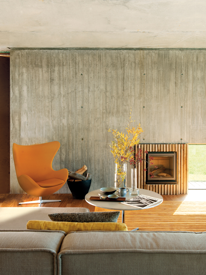 00375314. Butaca Egg, de Arne Jacobsen. Mesa de centro A222, de Piet Hein, Bruno Mathsson y Arne Jacobsen. Todo lo produce Fritz Hansen. Sobre la mesa, cerámica de la artista danesa Ulla Sutton. Chimenea, de Stûv