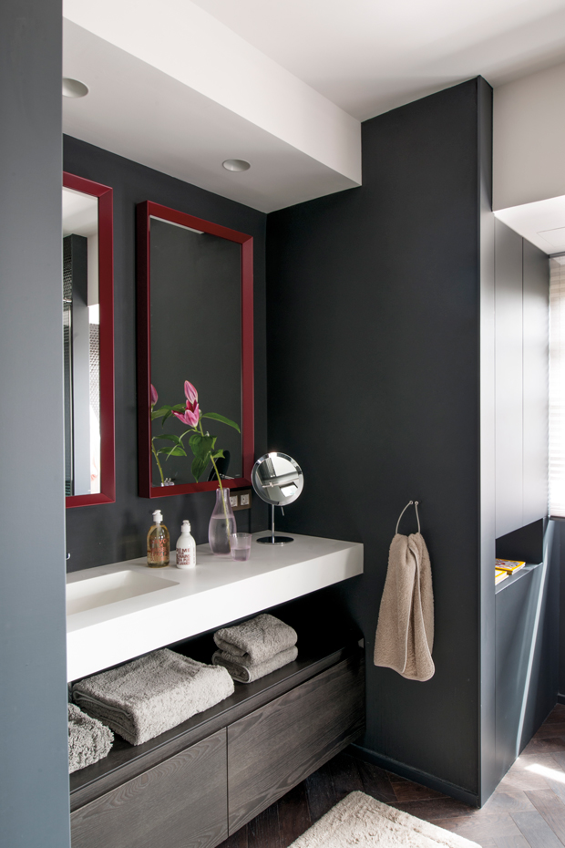 00440689. En el baño, baldosas de gresite hexagonal color negro brillo, de Hisbalit. Espejos, de Antonio Lupi; mueble bajolavabo, de Bayur, y accesorios, de Agape