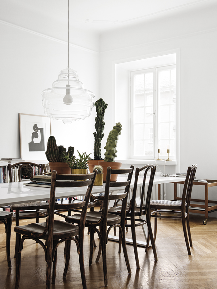 En casa de H&M 12. La mesa, de Thomas Eriksson para Asplund, se rodea de una mezcolanza de sillas antiguas compradas en mercadillos