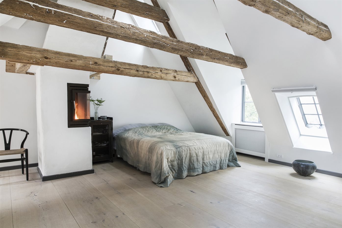 Rene-Redzepi2. La habitación principal se encuentra bajo la cubierta inclinada, caldeada por una chimenea cerrada