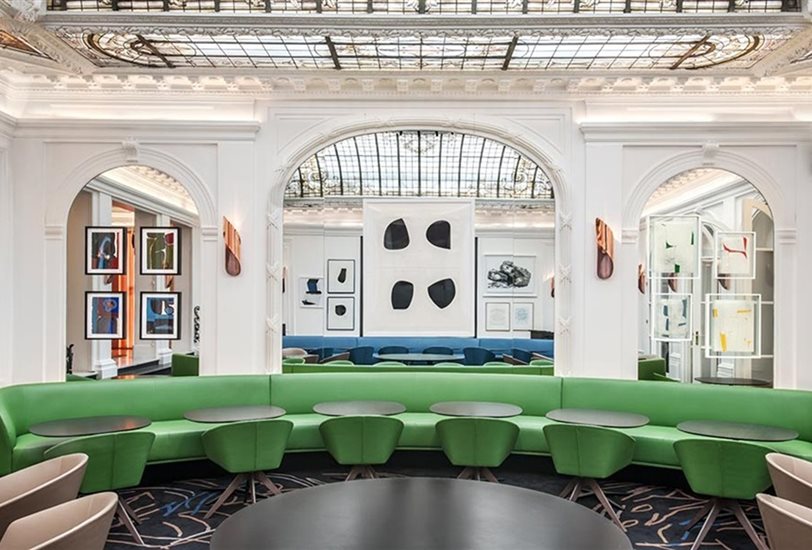 Bajo la cúpula de cristal diseñada por Gustave Eiffel, los sillones Brandy tapizados de verde magenta