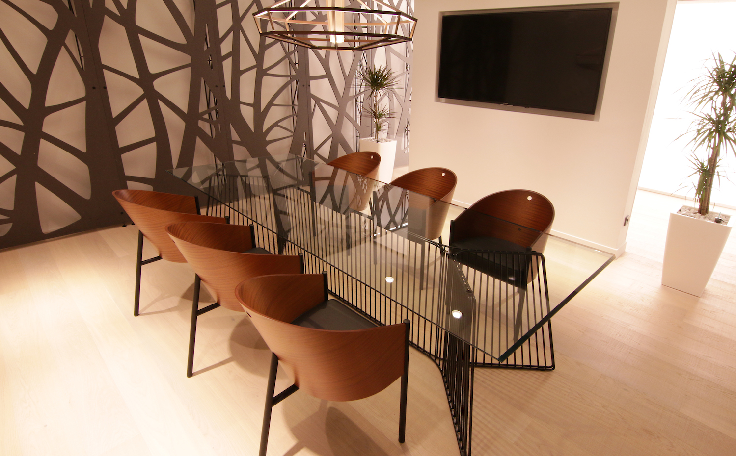 Estudio 3. La escultural mesa de cristal se combina con sillas moldeadas de madera