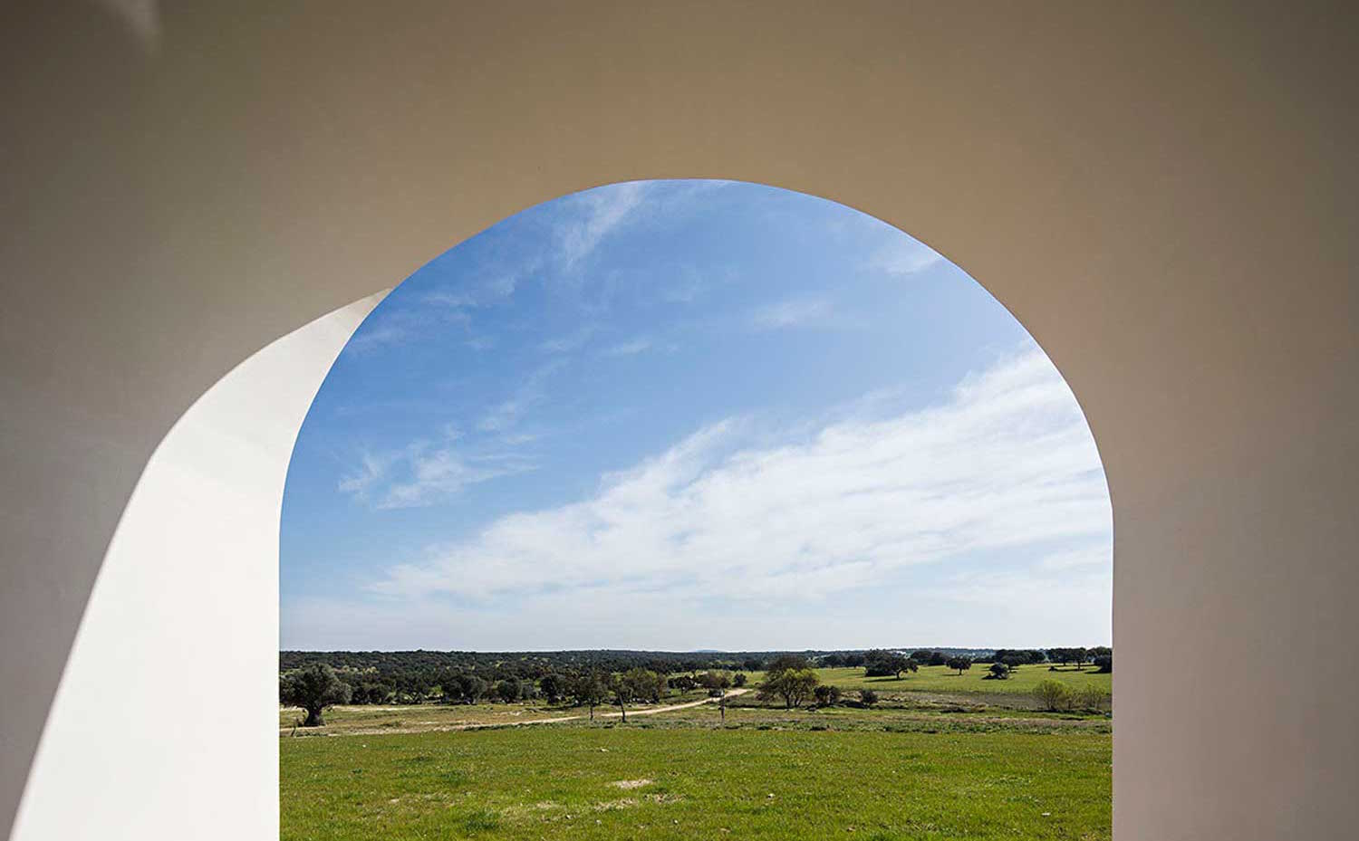 AIRES-MATEUS-1. Una arcada enmarca el campo y los pastos de esta finca de mil hectáreas con río, estanques y alcornoques