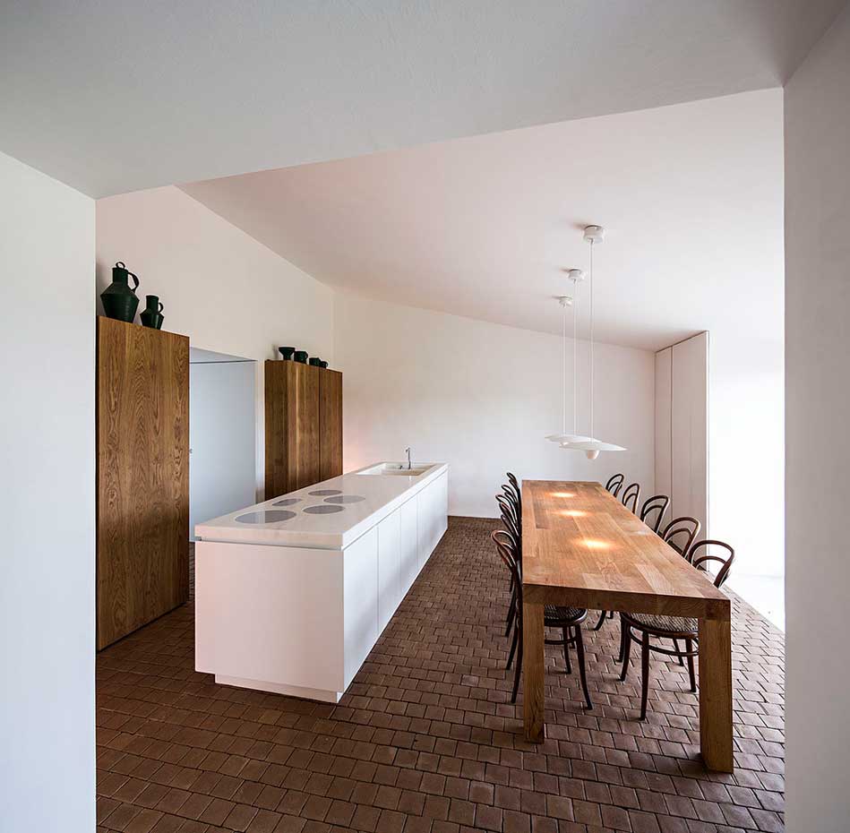 AIRES-MATEUS-3. La cocina exhibe líneas geométricas y actuales que encajan a la perfección en la austeridad estética del interior. La encimera de la isla, de mármol blanco, integra las placas de cocción