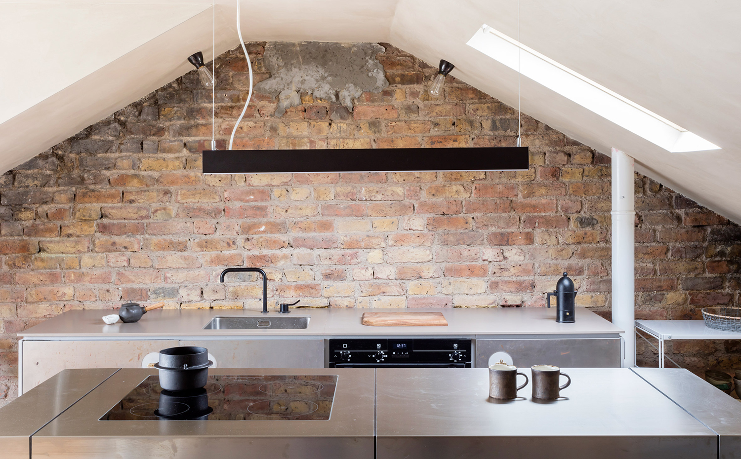 clay-house-simon-astridge-interiors-london-uk-residential dezeen 2364 col 5. Las paredes originales de ladrillo de la planta superior se dejaron expuestas tras la reforma
