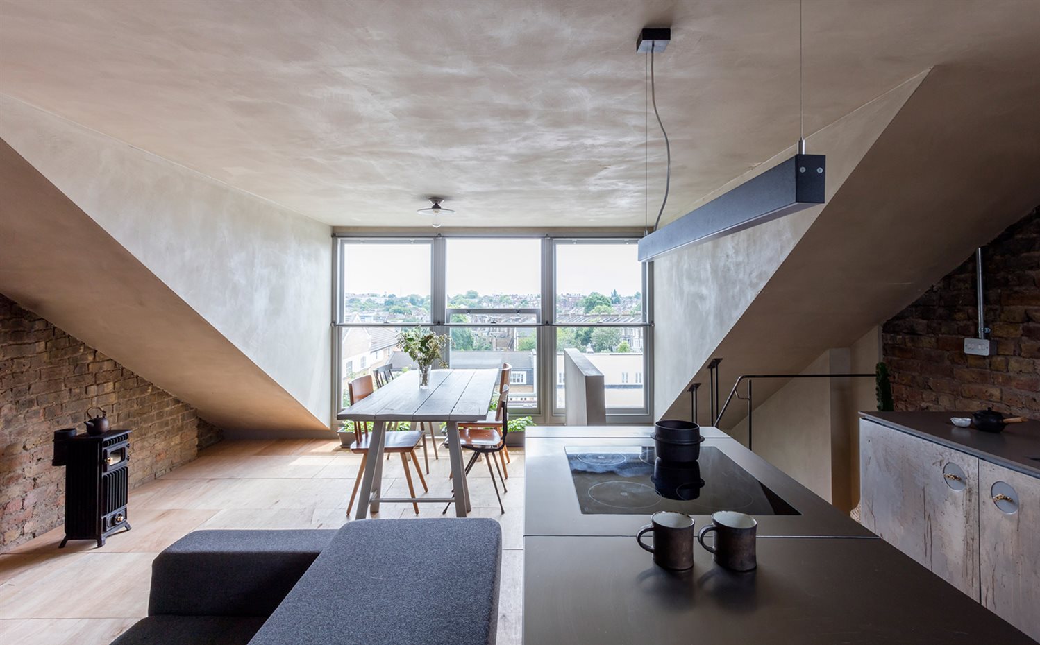 clay-house-simon-astridge-interiors-london-uk-residential dezeen 2364 col 6. La planta superior abuhardillada alberga unificado el salón, la cocina y el comedor