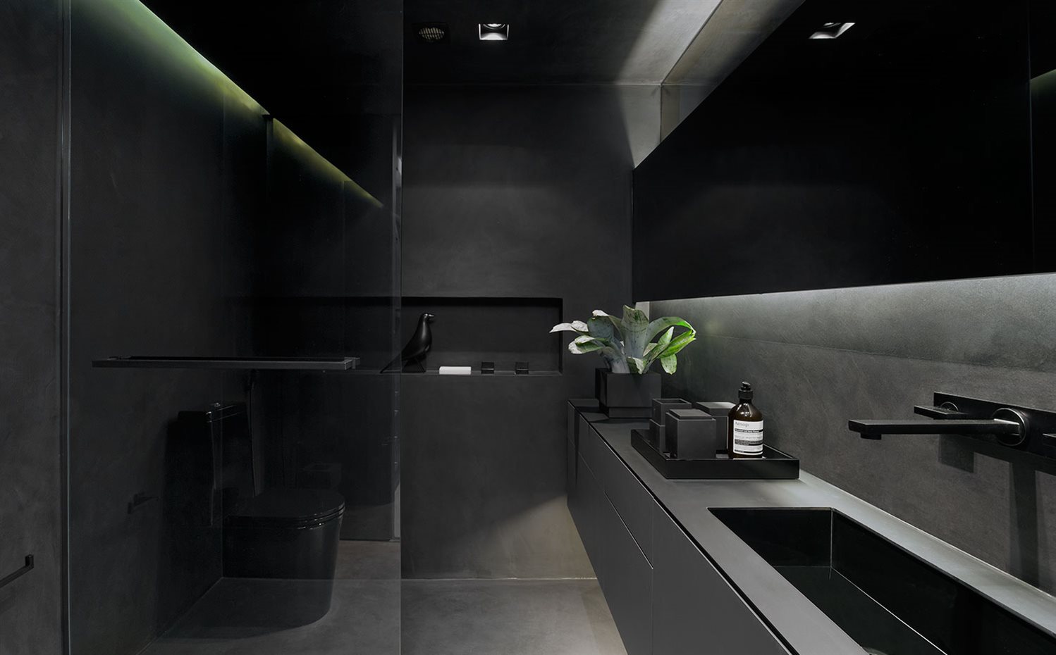 Baño. El baño tiene un revestimiento (techo, suelo y paredes) de cemento pulido negro