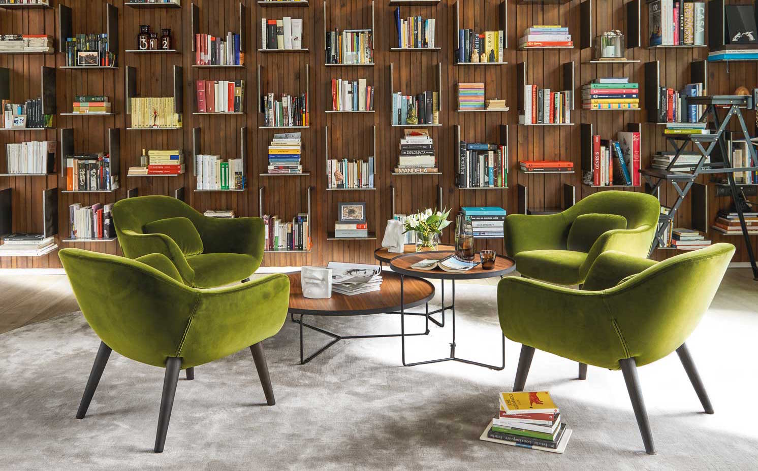 00445710. La librería que protagoniza este ambiente es un diseño de los arquitectos, hecha a medida con madera de nogal Canaletto. Las butacas son el modelo Mad, de Marcel Wanders para Poliform, tapizadas con terciopelo verde oliva. Como gran parte del mobiliario, proceden de Gunni & Trentino