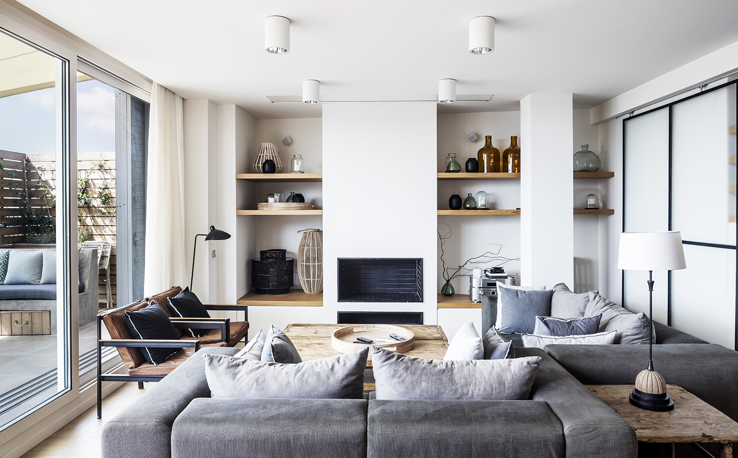  AG 0714. En el estar, los sofás de diseño propio con líneas suaves y tejido verde militar natural se combinan con lámparas de los años cincuenta, sillones industriales y mesas robustas envejecidas