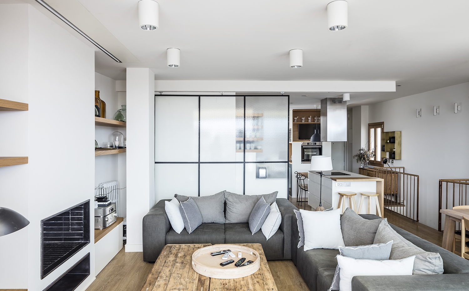  AG 0719. Una puerta corredera de hierro negro y cristal, inspirada en los lofts de Nueva York, da el punto más industrial de todo el apartamento y se utiliza como separador entre la cocina y el salón