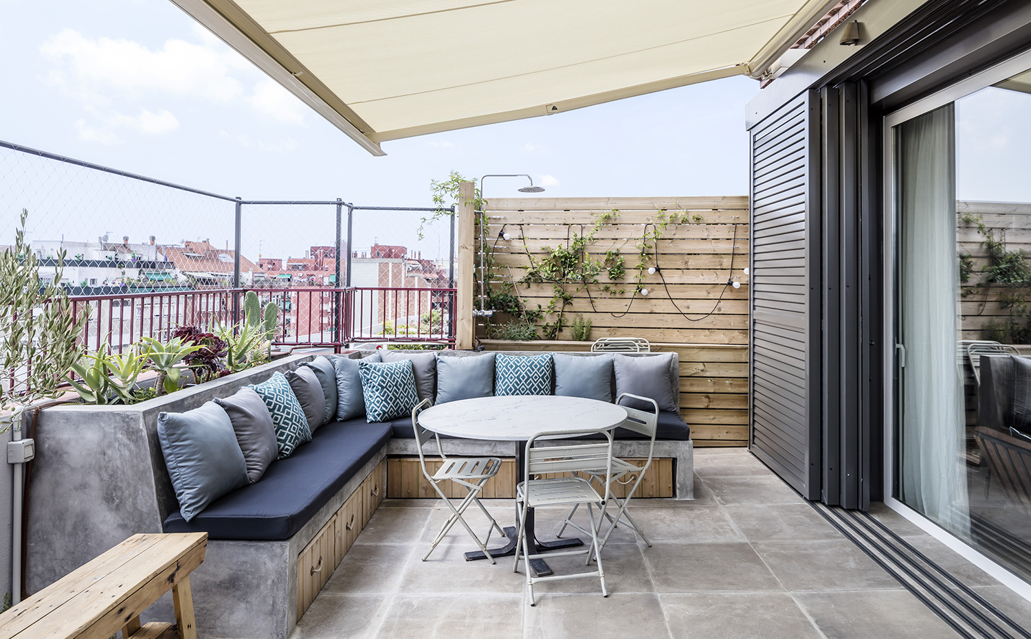  AG 0740. En la terraza dominan las tonalidades grises por la profundidad y calidez que aportan. Los bancos de obra están ahuecados por debajo para guardar prácticas cajas de madera