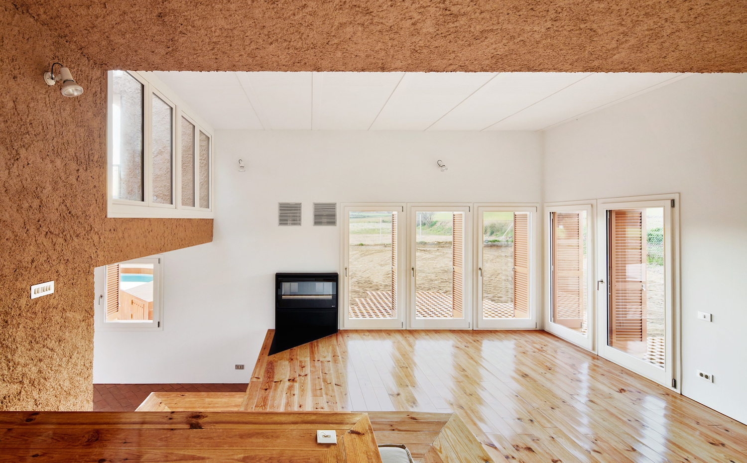 Can Migris. El cuidado que han puesto Arquitectura G en esta casa se puede apreciar en pequeños gestos como en la chimenea integrada en la pared, que incorpora una pequeña lámina metálica en el suelo para evitar la suciedad.