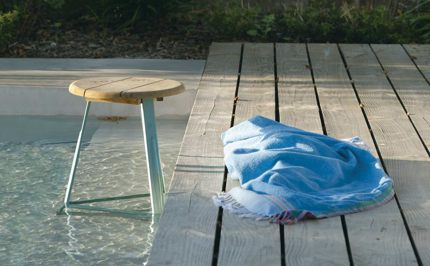 Los pavimentos que rodean la corona de la piscina deben revestirse con productos antideslizantes, como estos tablones de madera