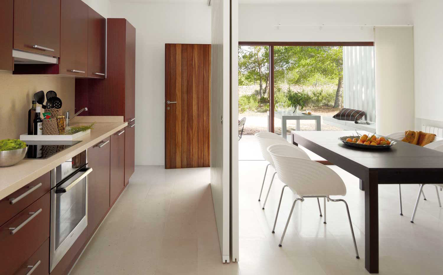 00311160. Las puertas deslizantes comunican o aíslan la cocina y el comedor. Encimera de Silestone, grifería de Roca y sillas Tom Vac de Vitra.