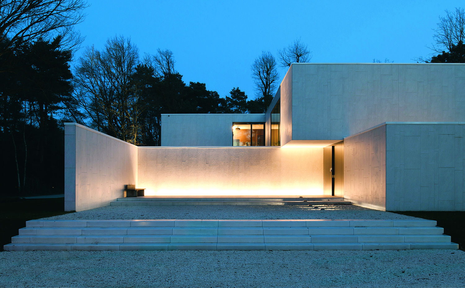 La iluminación perimetral nocturna da relieve a los muros de esta casa de Cubyc Architects