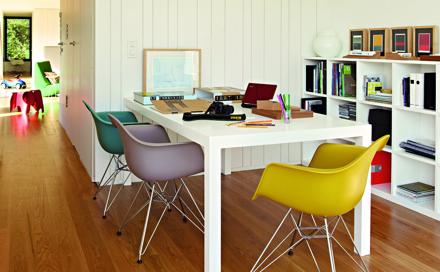 ARQUITECTURA 166-1. La ergonomía busca que la persona se sienta tan cómoda que se "olvide" de su cuerpo y se concentre en la actividad. Sillas Plastic Armchair DAR, diseño de los Eames que edita Vitra