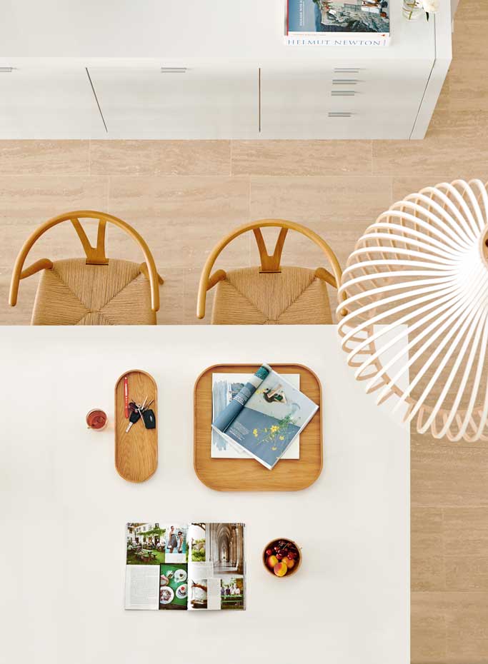 00387689. La mesa de comedor, extensible y lacada de blanco, se ha hecho a medida. Sillas CH24 Wishbone Chair, de Hans J. Wegner para Carl Hansen & Søn, en Arkitektura. Lámpara Octo Pendant, de Seppo Koho para Secto Design, en Nordic Think. Bandejas de madera, de Hay, adquiridas en Arkitektura