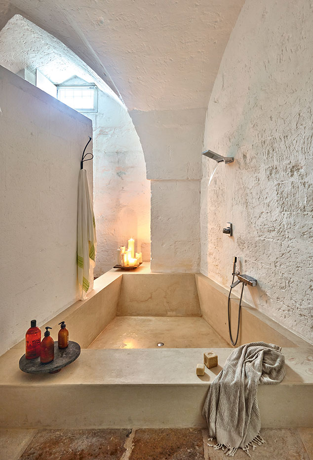 00403444. Las texturas de la piedra caliza de las paredes y la bañera dotan al espacio del baño de una cualidad ancestral. La grifería es de la colección Faraway, diseño de los arquitectos para Zuchetti
