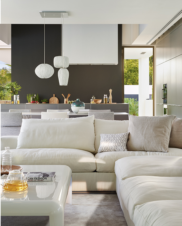 Salón moderno abierto as la cocina con sofá blanco. 