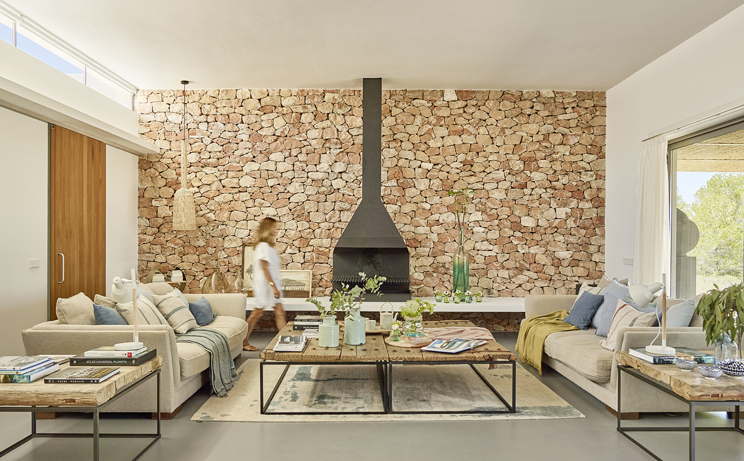 Salón con pared de piedra y chimenea. 