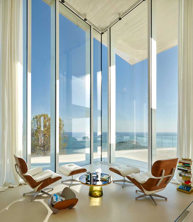 00403373 O. Lounge Chair & Ottoman de piel blanca, diseño de Charles & Ray Eames que edita Vitra. Mesita de centro Bell, creación de Sebastian Herkner para ClassiCon. Junto al sofá, la lámpara de sobremesa AJ Table, diseño de Arne Jacobsen para Louis Poulsen