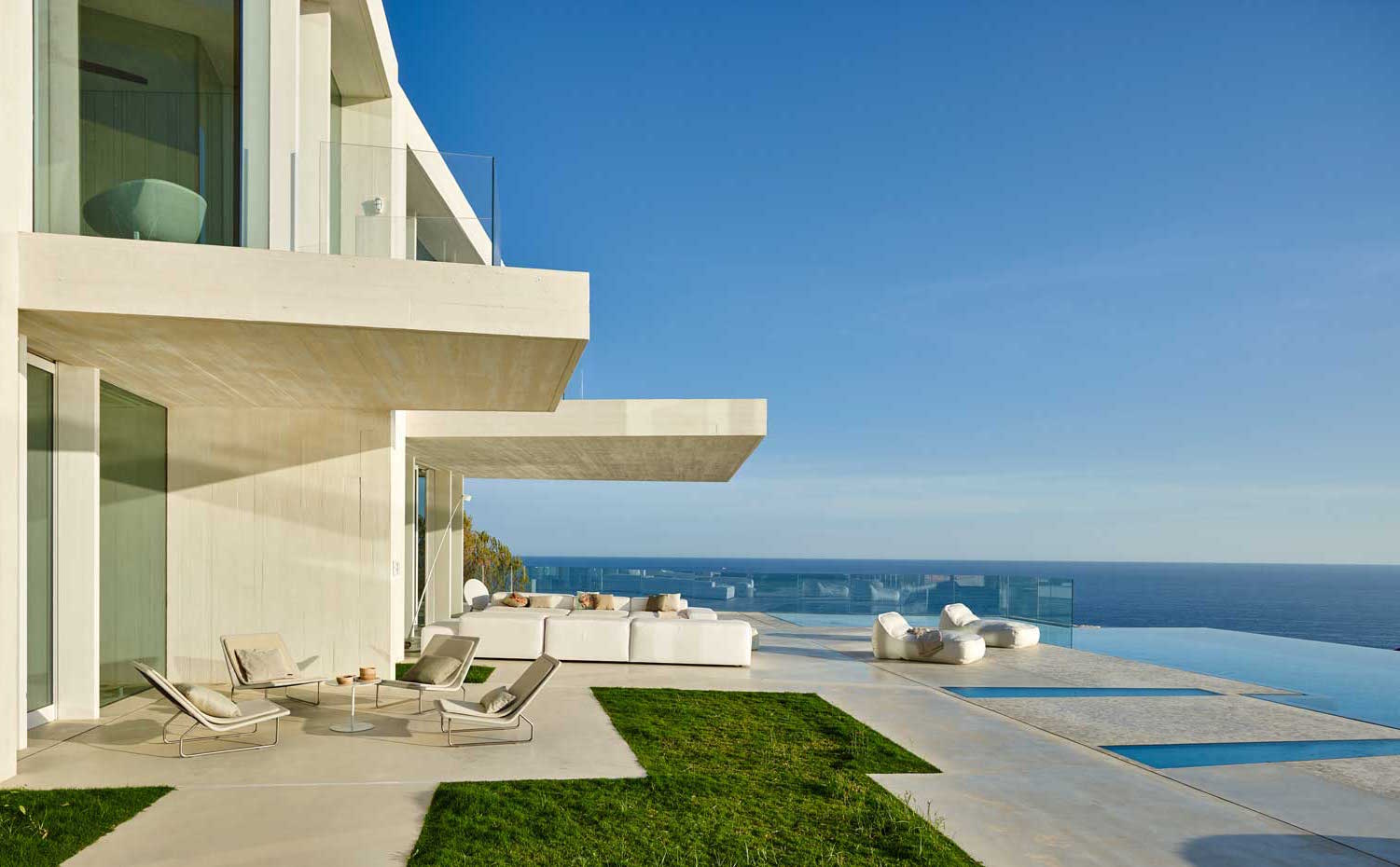 1. La lámina de agua de la piscina desbordante se funde con el Mediterráneo. Junto a ella, la butaca Sand y la tumbona re-donda Ease, diseño de Francesco Rota para Paola Lenti. Los pavimentos interiores y exteriores son de microcemento